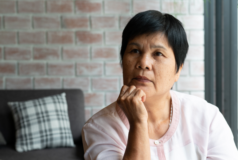 Woman resting her chin on her hand with a pensive expression