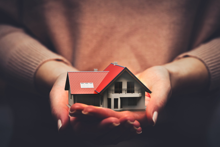 Cupped hands holding a model house