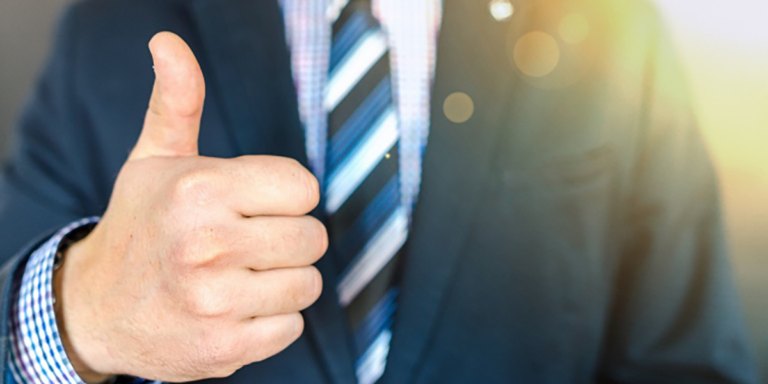 Man in a suit giving a thumbs up