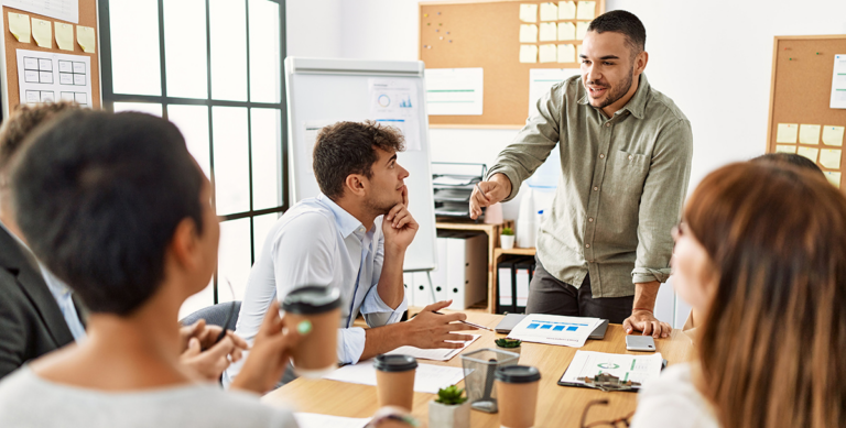 Man leading a discussion with coworkers around a conference table