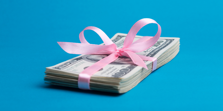 Stack of hundred-dollar bills tied with a ribbon bow