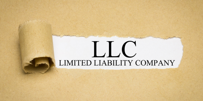 Torn brown paper revealing text underneath reading LLC Limited Liability Company