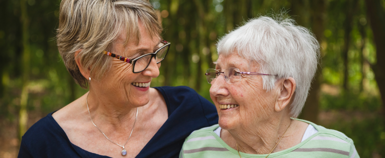 Two older women sitting together outdoors